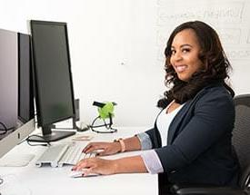 female student in business attire at computer